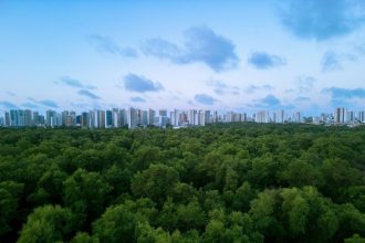 Vista aérea de Fortaleza, com a área urbana integrada a uma extensa faixa de vegetação.
